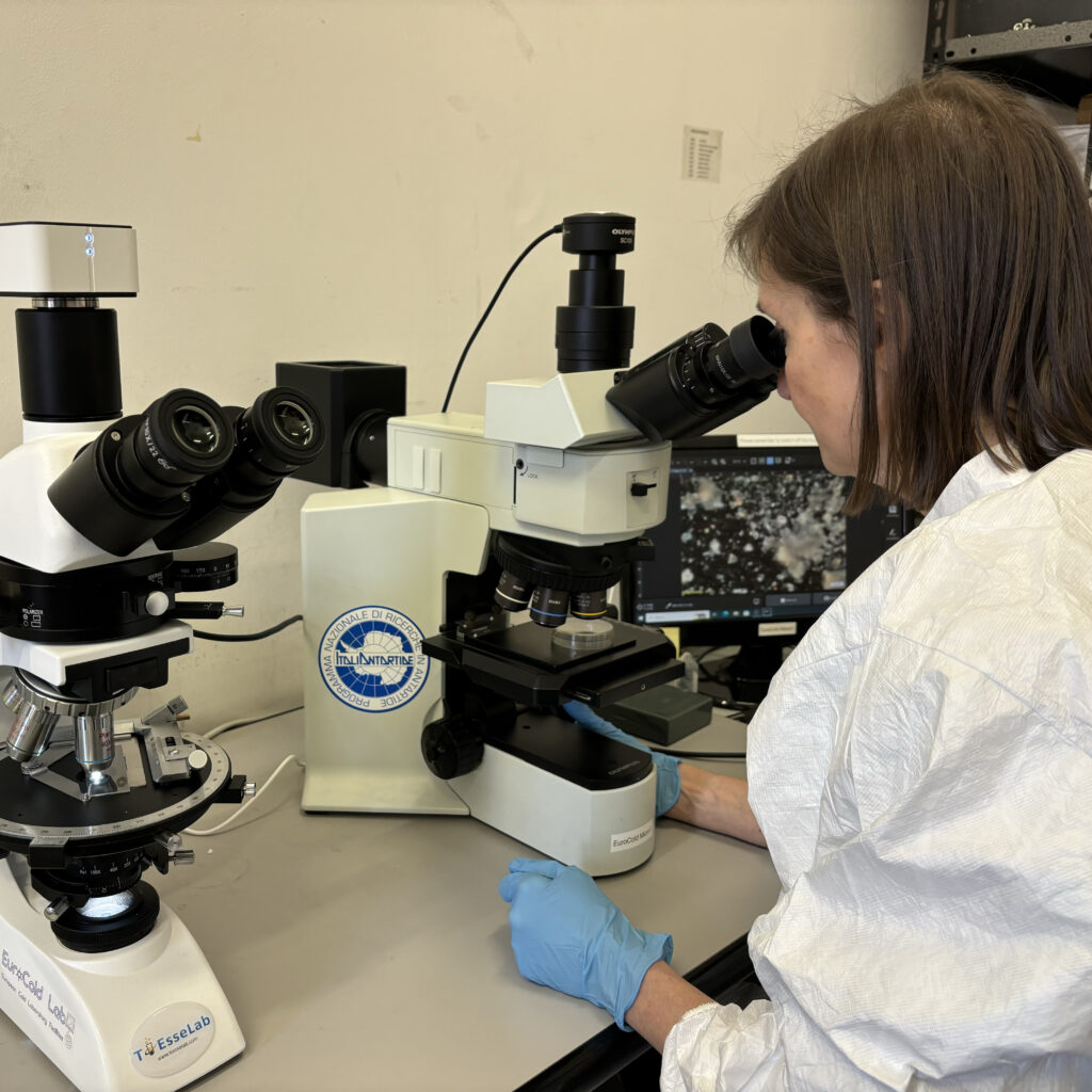 Donna che osserva al microscopio