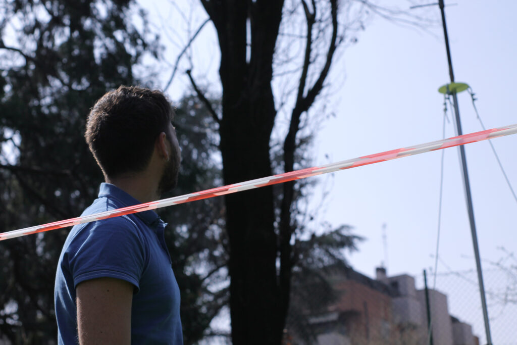 Ricercatore che osserva qualcosa all'interno di un'area delimitata da nastro rosso e bianco