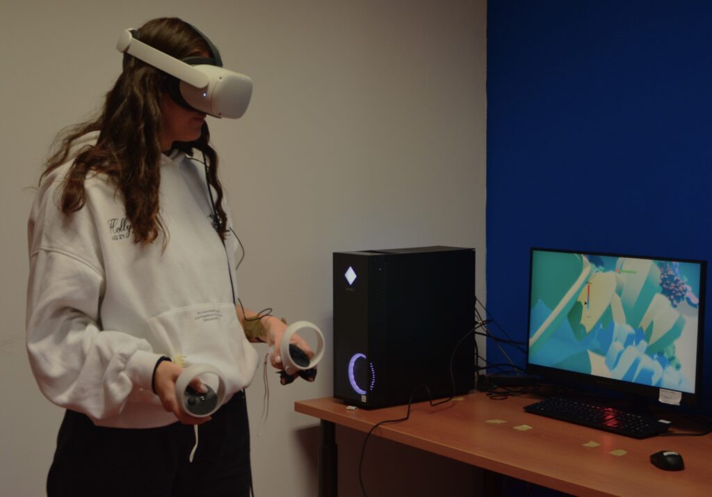 Ragazza colta mentre utilizza un visore per la realtà aumentata in un laboratorio didattico. 