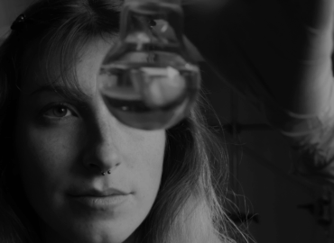 Foto in bianco e nero del volto di una ragazza che tiene in mano una provetta