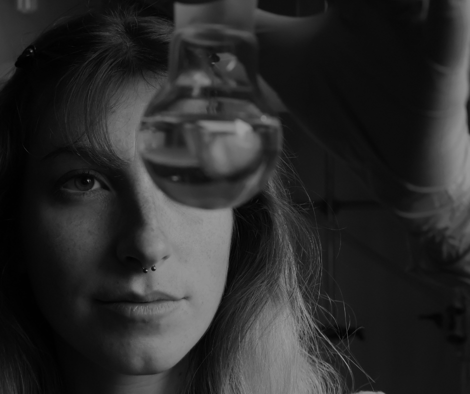 Foto in bianco e nero del volto di una ragazza che tiene in mano una provetta